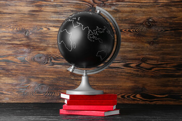 Globe with books on wooden background