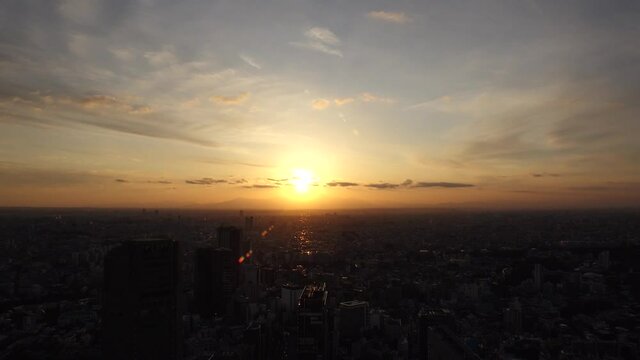 TOKYO, JAPAN : Aerial sunrise CITYSCAPE of TOKYO and MOUNT FUJI. View of rising sun and buildings around Shibuya. Japanese city life and nature concept. Time lapse zoom out video, night to morning.