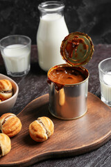 Tin can of boiled condensed milk on dark background