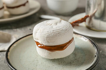 Tasty marshmallows with boiled condensed milk on grunge background