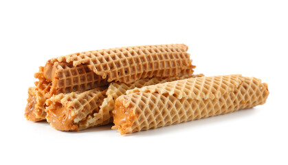 Tasty wafer rolls with boiled condensed milk on white background