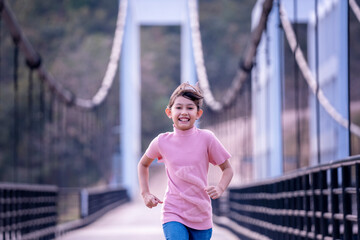 Beauty happy girl enjoy running freedom over Bridge. Funny kid playing outdoor. Happy child free on  spring day