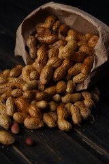 nuts peanuts in a shell on a wooden background in a craft bag. High quality photo