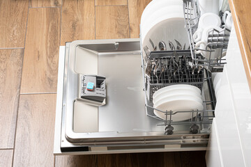 Open dishwasher with clean utensils in it