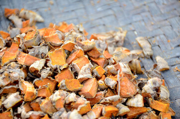 the slice brown orange ripe turmeric on the brown wooden background.