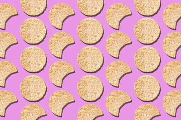 Pattern of round gluten-free rice cakes on purple background