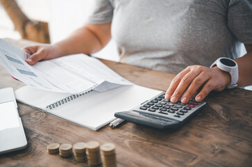 The woman who is a housewife is checking the expenses. From the creditor bill sent to. Calculate...