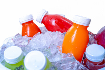 Organic cold pressed raw vegetable and fruit juice bottle in crushed ice bucket on white...