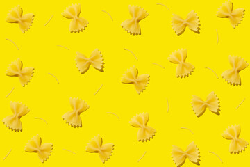 Raw farfalle pasta and noodles on yellow background