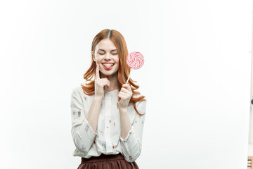 pretty woman with red hair holding lollipop in her hands charm