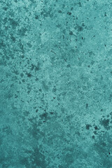 Abstract turquoise background with concrete texture and spots.