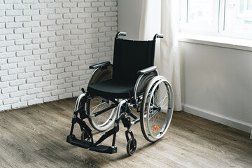 Fototapeta na wymiar Empty wheelchair in the hospital room near the window