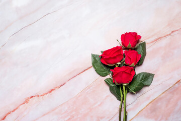 Bunch of red roses on a red marble background with copy space and room for text