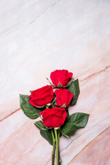 Bunch of red roses on a red marble background with copy space and room for text