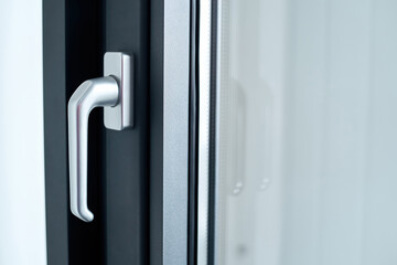 stylish chrome handle on a dark window frame. - 418260621