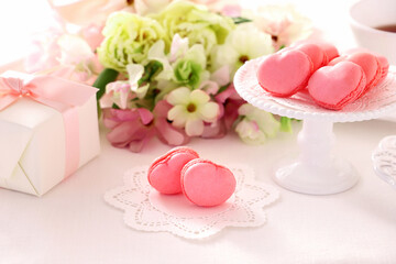 Heart shaped macarons with Beautiful bouquet of spring flowers and gift box on the table. 
Valentine or mothers day concept
ピンクのハート型マカロン スプリングブーケ　プレゼント