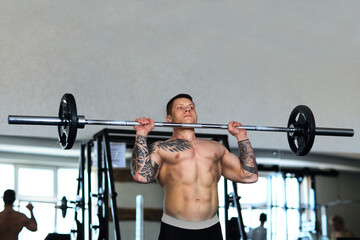 Fototapeta na wymiar bodybuilder works with a barbell in the gym.