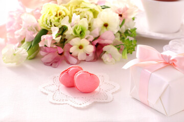 Heart shaped macarons with Beautiful bouquet of spring flowers and gift box on the table. 
Valentine or mothers day concept
ピンクのハート型マカロン スプリングブーケ　プレゼント