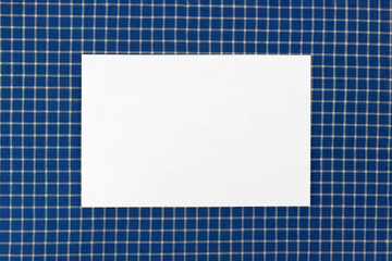 White business card mockup on blue classic checkered tablecloth texture, copy space