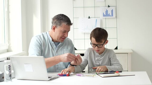 father and son tinker with electrical switches and sockets at the table
