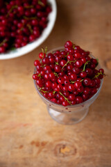 Currants in a bowl on a weeden background. Red berry. Vitamin berries. Copy space