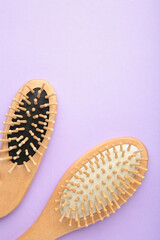 Fototapeta na wymiar Set of comb and hairbrush on purple background with copy space. Vertical foto