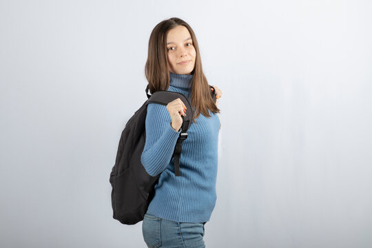 Portrait photo of a young girl model standing with backpack and posing