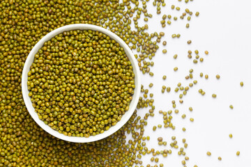 Close up of Organic green Gram (Vigna radiata)  on a ceramic white bowl with the gradient background of whole green moong dal. Top view 