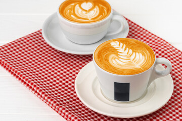 Cup of hot coffee with art on froth