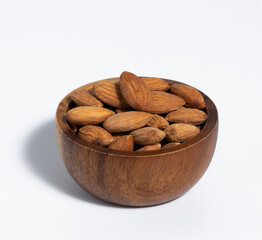 Roasted almond in wooden bowl on white background