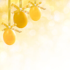 Yellow easter eggs hang on ribbon