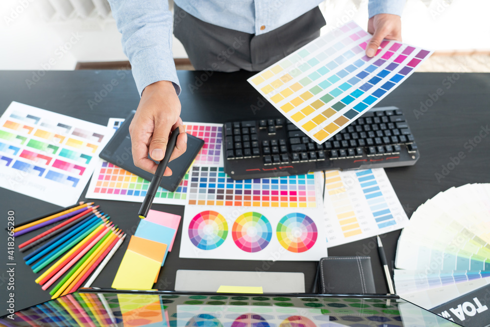 Poster creative graphic designer choosing color scale for editing artwork while working in office.