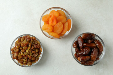 Glass bowls with dried food on white textured background