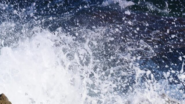 Big waves crashing on the rocks cliff.  Slow motion. View from above