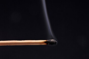 Allumette éteinte avec de la fumée en gros plan sur fond noir