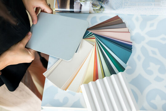 Close up of woman choosing materials for home renovation. interior designer looking at color samples for wall. Real estate, home decoration, small business