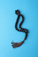 Rosary or prayer beads on blue background
