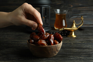 Ramadan concept on wooden background with Female hand hold date