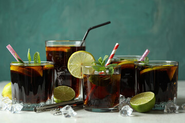 Glasses of Cuba Libre on white textured table against green background