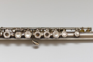 Silvery musical instrument with keys on a white background with soft shadow