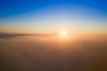 Dawn or sunset over the clouds, blue hour, aerial view.