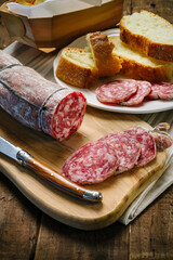Salami sliced on wooden cutting board