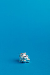 Empty chocolate candy wrapper on blue background.