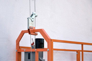 Hoist supply and safety lock as part of suspended wire rope platform for facade works on high...