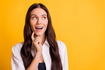 Portrait of cheerful person arm finger on chin open mouth look empty space isolated on yellow color...