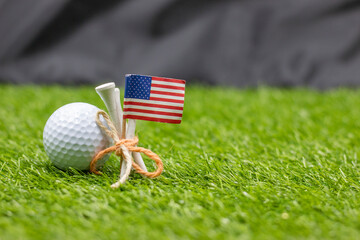 Golf ball with flag of America are on green grass
