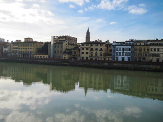 Fototapeta na wymiar View of the River Arno with historic buildings in the morning. Scenic landscape with old stone building. Travel to European Union. UNESCO World Heritage Site.