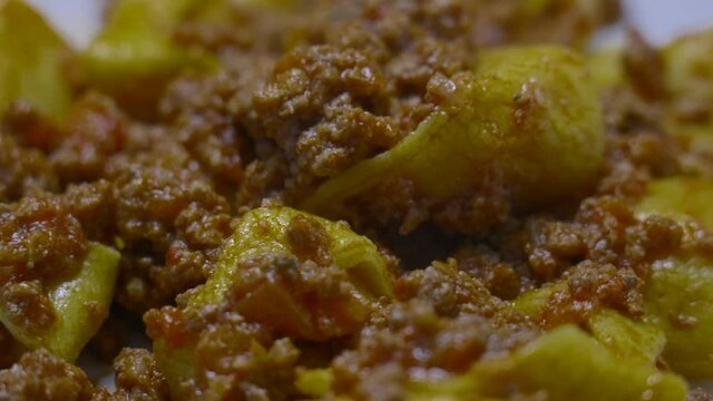 Pumpkin tortellini with meat sauce. Cappellacci with pumpkin is a homemade Italian pasta made with flour and eggs, typical of Ferrara, Emilia Romagna, Bologna, served with meat sauce and tomato.