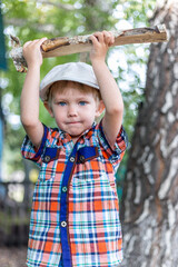 the child cuts wood with an axe and throws it into a pile