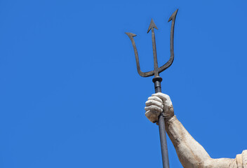 The mighty god of water and sea Neptune (Poseidon, Triton). Neptun's trident as symbol strength, power and unrestraint. Fragment of an ancient statue. Copy space for text or design. © zwiebackesser